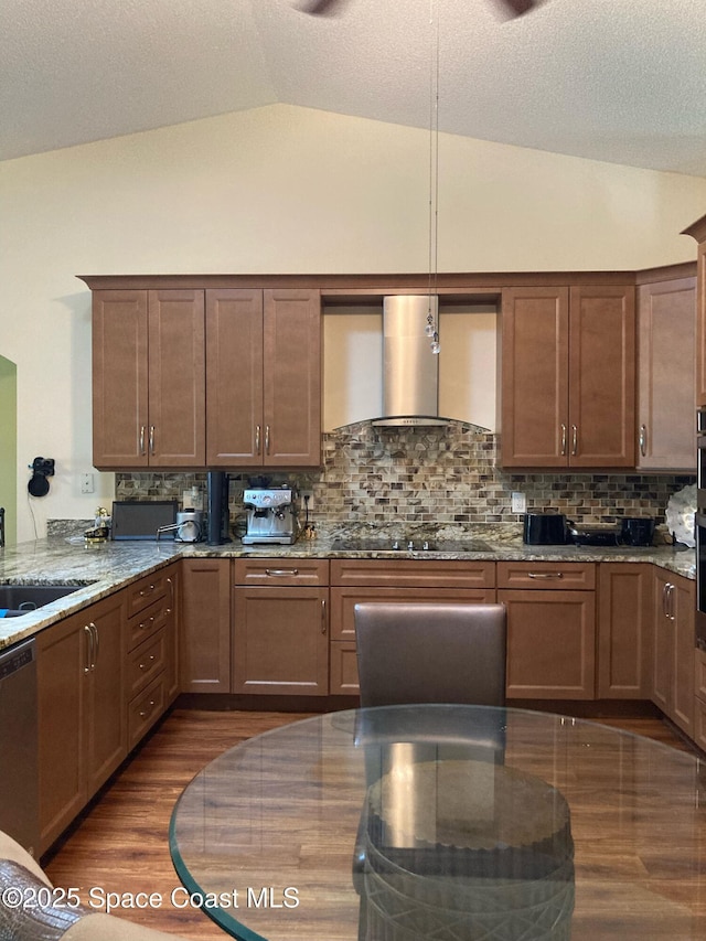 971 Sabal Grove Dr, Rockledge, FL 32955 - kitchen featuring lofted ceiling, wall chimney range hood, dark wood finished floors, light stone counters, and tasteful backsplash