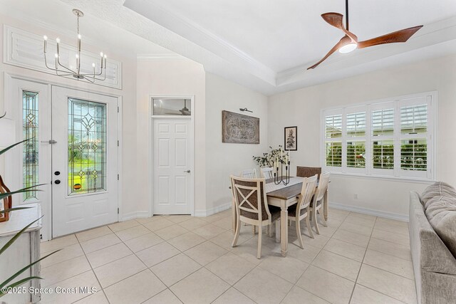 1172 Vestavia Cir, Melbourne, FL 32940 - dining room featuring a chandelier, light tile patterned flooring, a tray ceiling, ornamental molding, and healthy amount of natural light