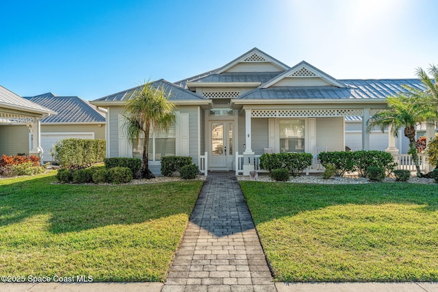 1172 Vestavia Cir, Melbourne, FL 32940 - view of front of house featuring a front lawn, metal roof, a standing seam roof, and a porch