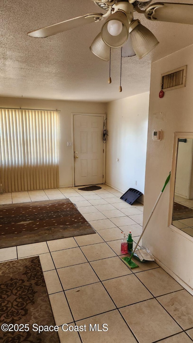 2327 Sadler Ln, Melbourne, FL 32935 - foyer featuring light tile patterned flooring, ceiling fan, and a textured ceiling