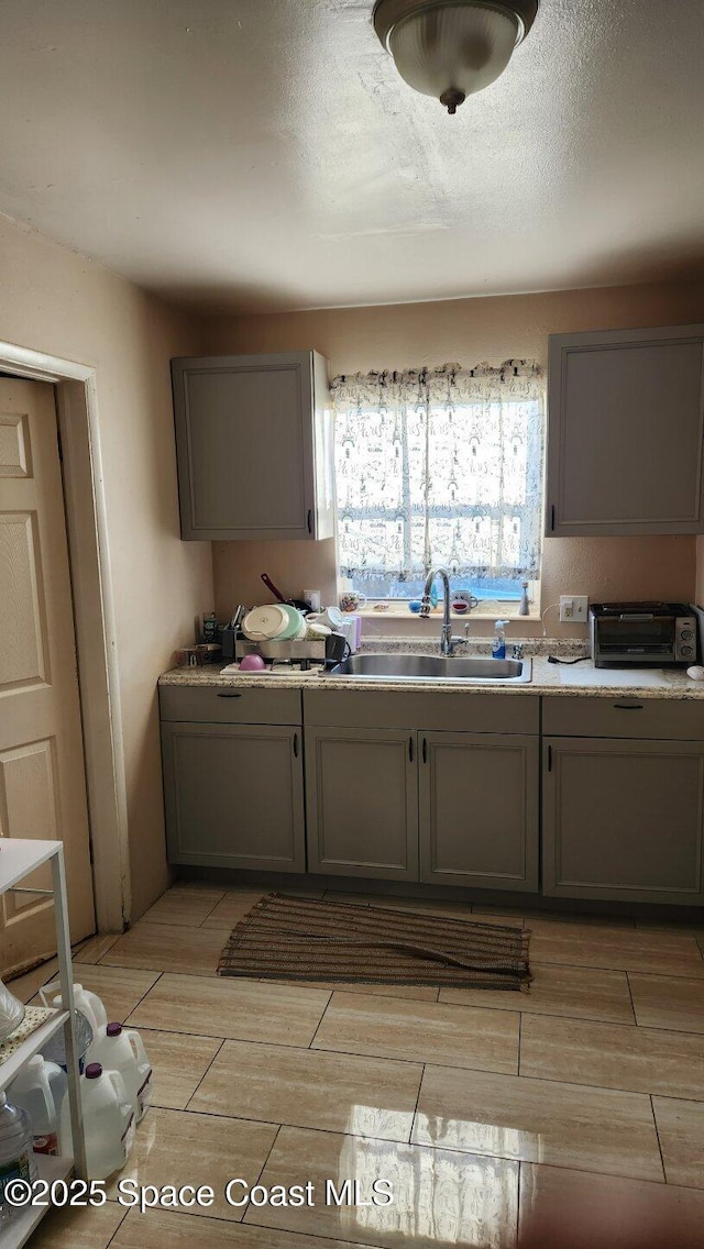 2327 Sadler Ln, Melbourne, FL 32935 - kitchen featuring a sink, gray cabinets, light countertops, and wood tiled floors