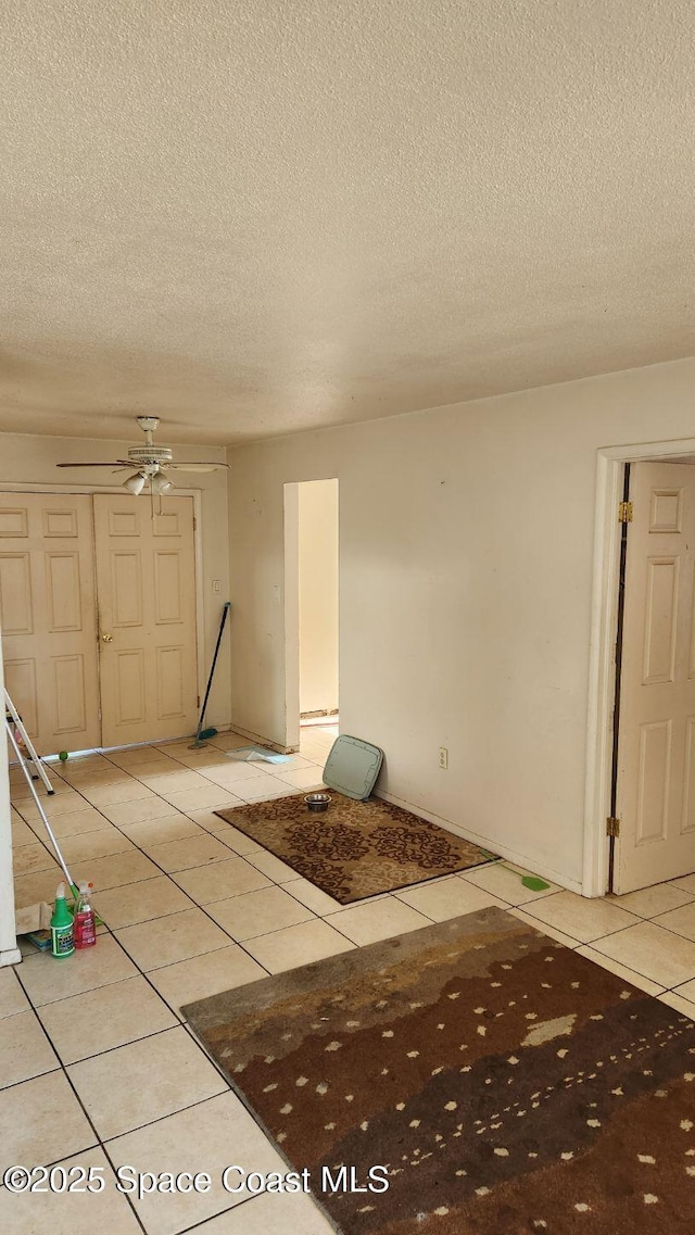 2327 Sadler Ln, Melbourne, FL 32935 - empty room featuring light tile patterned floors, a textured ceiling, and a ceiling fan