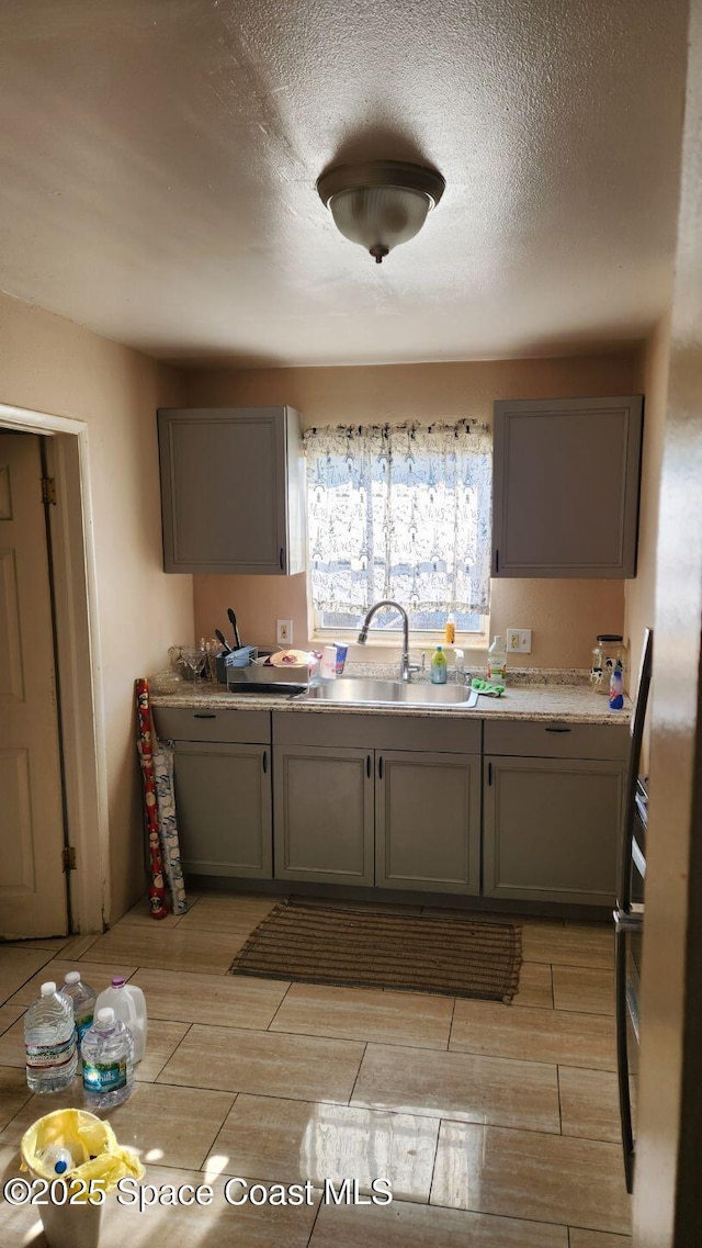 2327 Sadler Ln, Melbourne, FL 32935 - kitchen featuring a sink, gray cabinets, wood finish floors, and a textured ceiling