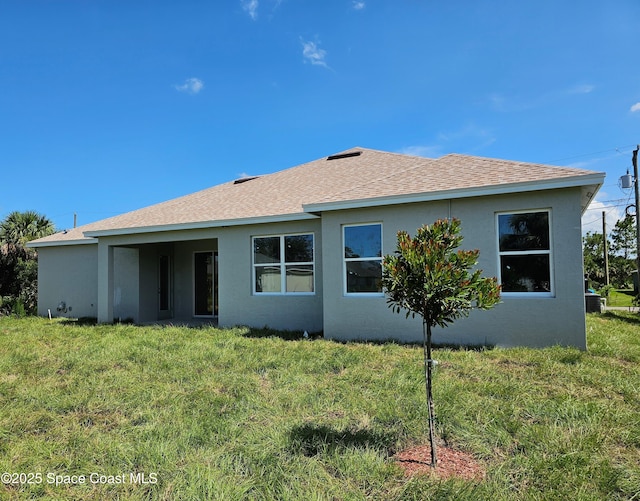 571 Fondulac St, Palm Bay, FL 32908 - back of house featuring stucco siding and a lawn