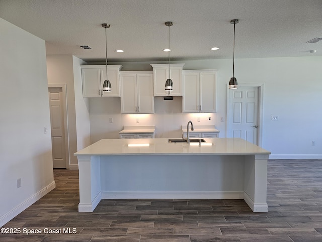 571 Fondulac St, Palm Bay, FL 32908 - kitchen featuring dark wood-style floors, an island with sink, recessed lighting, white cabinets, and a textured ceiling