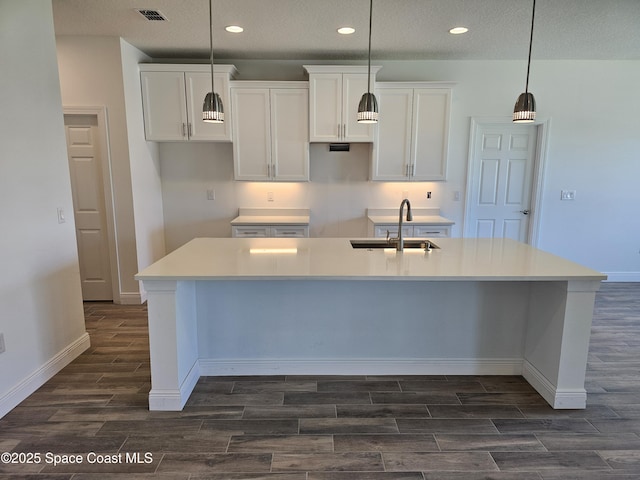 571 Fondulac St, Palm Bay, FL 32908 - kitchen featuring wood tiled floors, a large island with sink, white cabinets, recessed lighting, and a textured ceiling