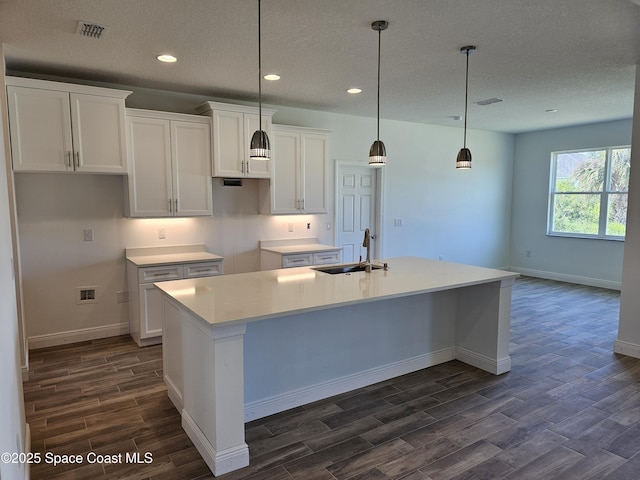 571 Fondulac St, Palm Bay, FL 32908 - kitchen featuring dark wood-style flooring, a textured ceiling, an island with sink, white cabinets, and recessed lighting