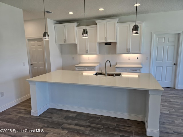 571 Fondulac St, Palm Bay, FL 32908 - kitchen featuring dark wood-style flooring, white cabinetry, a large island with sink, recessed lighting, and pendant lighting