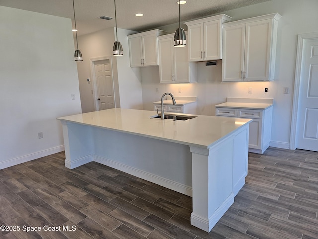 571 Fondulac St, Palm Bay, FL 32908 - kitchen with white cabinets, a kitchen island with sink, dark wood-style flooring, recessed lighting, and pendant lighting