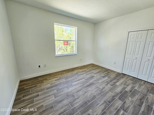 571 Fondulac St, Palm Bay, FL 32908 - unfurnished bedroom with dark wood finished floors, a closet, and a textured ceiling