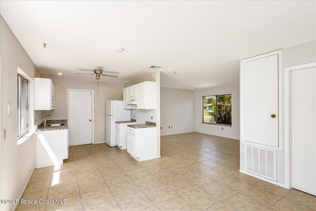 933 Gueld Ave NE, Palm Bay, FL 32905 - kitchen with ceiling fan, open floor plan, white cabinets, light tile patterned floors, and light stone counters