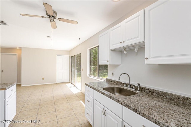 933 Gueld Ave NE, Palm Bay, FL 32905 - kitchen with white cabinetry, ceiling fan, and light tile patterned flooring