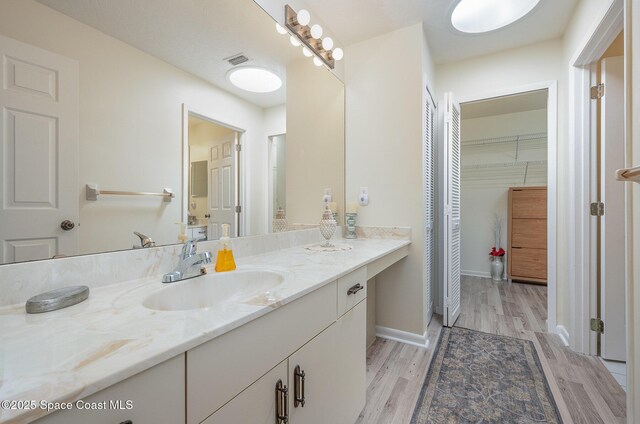 960 Mayflower Ave, Melbourne, FL 32940 - bathroom with vanity, wood finished floors, a spacious closet, and baseboards
