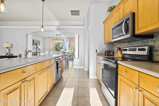 2922 Brandywine Cir, Titusville, FL 32796 - kitchen with stainless steel appliances, tasteful backsplash, light tile patterned flooring, light countertops, and a sink