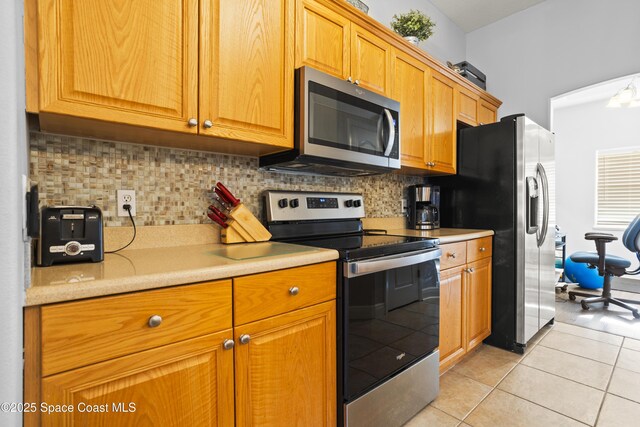 2922 Brandywine Cir, Titusville, FL 32796 - kitchen with appliances with stainless steel finishes, light countertops, decorative backsplash, and light tile patterned floors