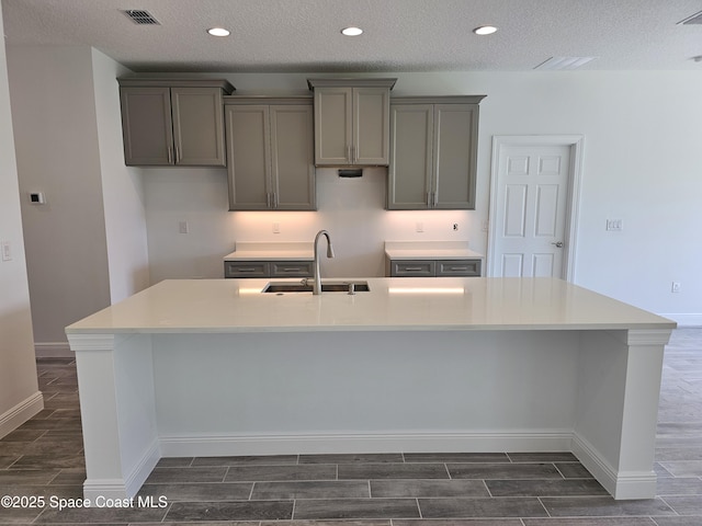 2999 Gaffney Ave SE, Palm Bay, FL 32909 - kitchen featuring gray cabinetry, wood tiled floors, a large island, a textured ceiling, and recessed lighting