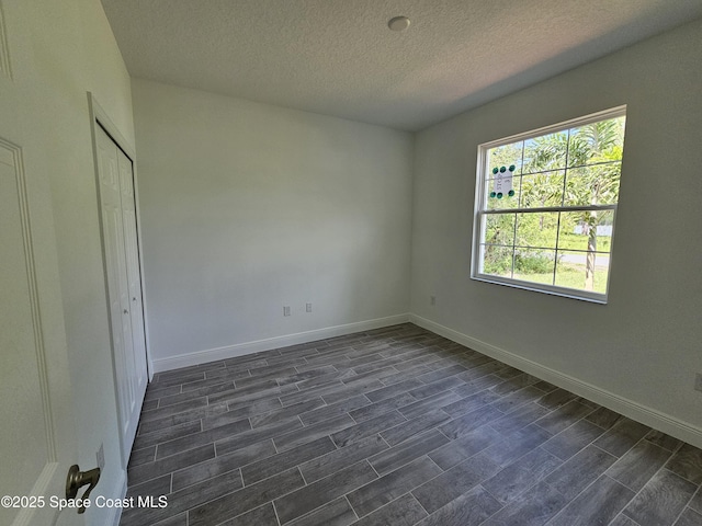 2999 Gaffney Ave SE, Palm Bay, FL 32909 - unfurnished bedroom with dark wood-type flooring, a textured ceiling, and a closet