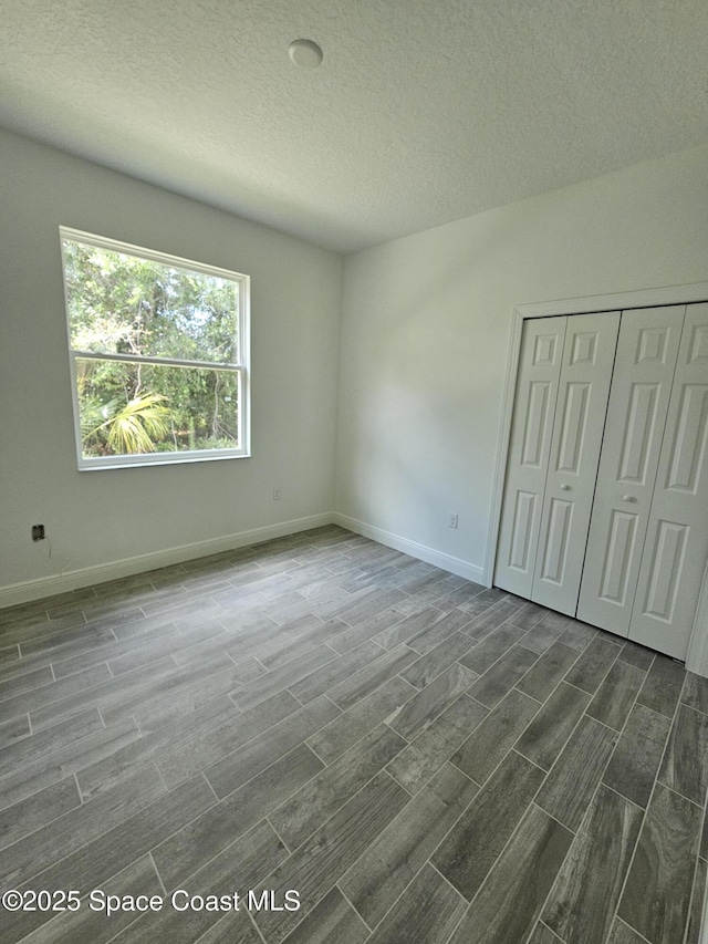 2999 Gaffney Ave SE, Palm Bay, FL 32909 - unfurnished bedroom with wood finish floors, a textured ceiling, and a closet
