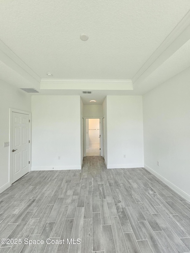 2999 Gaffney Ave SE, Palm Bay, FL 32909 - spare room with ornamental molding, light wood finished floors, a textured ceiling, and a raised ceiling