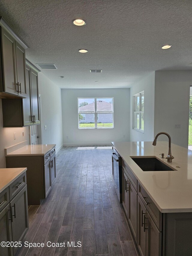 2999 Gaffney Ave SE, Palm Bay, FL 32909 - kitchen featuring dark wood-style floors, a textured ceiling, dishwasher, recessed lighting, and light countertops