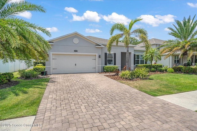 4570 Hebron Dr, Merritt Island, FL 32953 - ranch-style home featuring decorative driveway, a front yard, stucco siding, and a garage