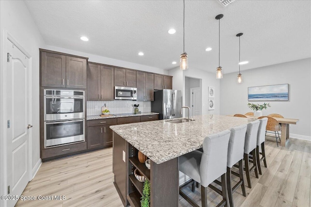 4570 Hebron Dr, Merritt Island, FL 32953 - kitchen with appliances with stainless steel finishes, dark brown cabinetry, open shelves, light wood-type flooring, and recessed lighting