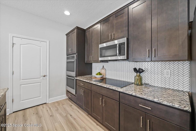 4570 Hebron Dr, Merritt Island, FL 32953 - kitchen featuring stainless steel appliances, light wood-type flooring, backsplash, light stone countertops, and a textured ceiling