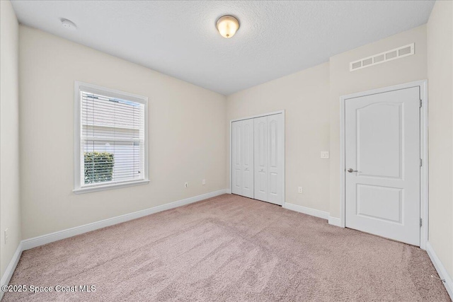 4570 Hebron Dr, Merritt Island, FL 32953 - unfurnished bedroom featuring carpet, baseboards, a textured ceiling, and a closet