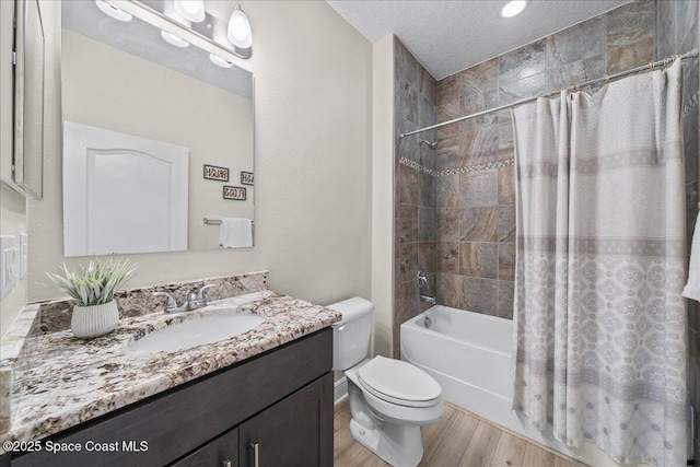 4570 Hebron Dr, Merritt Island, FL 32953 - full bath with toilet, wood finished floors, shower / bath combo with shower curtain, vanity, and a textured ceiling