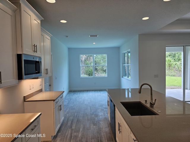 431 Falls Church St SW, Palm Bay, FL 32908 - kitchen with stainless steel microwave, recessed lighting, dark wood-style flooring, dishwasher, and white cabinetry