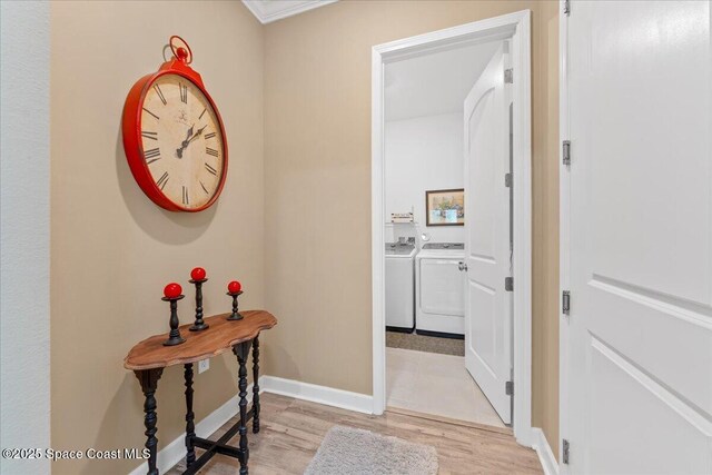 2889 Millennium Cir, Melbourne, FL 32940 - corridor featuring washing machine and clothes dryer, light wood-type flooring, and baseboards