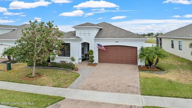 2889 Millennium Cir, Melbourne, FL 32940 - french country inspired facade with an attached garage, stucco siding, decorative driveway, a front lawn, and roof with shingles