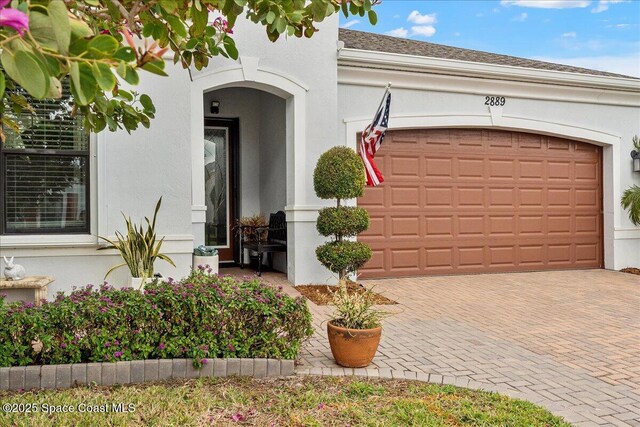 2889 Millennium Cir, Melbourne, FL 32940 - entrance to property with stucco siding, decorative driveway, and a garage