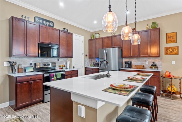 2889 Millennium Cir, Melbourne, FL 32940 - kitchen with stainless steel appliances, a sink, light wood finished floors, light countertops, and a kitchen bar
