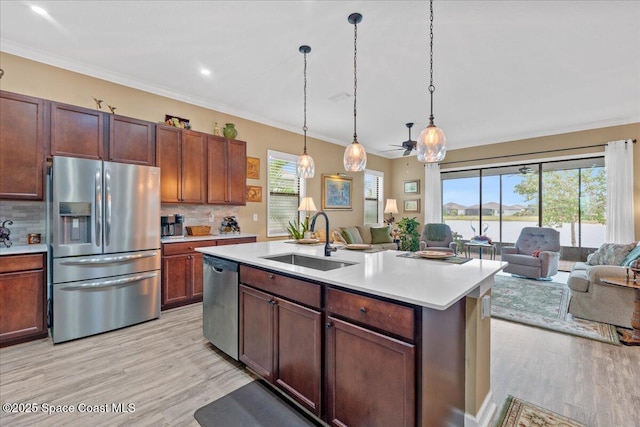 2889 Millennium Cir, Melbourne, FL 32940 - kitchen with stainless steel appliances, a sink, open floor plan, plenty of natural light, and ornamental molding