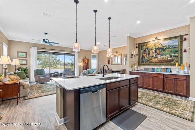 2889 Millennium Cir, Melbourne, FL 32940 - kitchen with stainless steel dishwasher, a sink, open floor plan, light wood-style floors, and light countertops