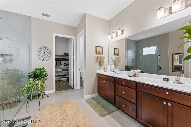 2889 Millennium Cir, Melbourne, FL 32940 - bathroom with a shower stall, tile patterned floors, double vanity, toilet, and baseboards
