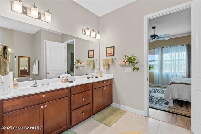 2889 Millennium Cir, Melbourne, FL 32940 - ensuite bathroom with baseboards, double vanity, ceiling fan, and tile patterned floors