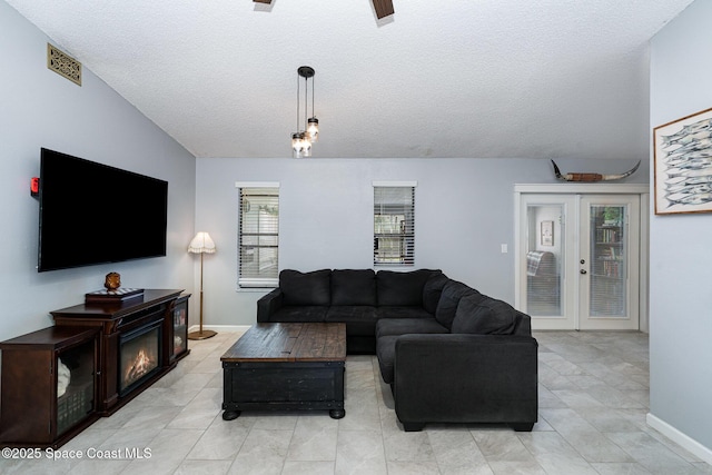 1035 Blau Ct NW, Palm Bay, FL 32907 - living room featuring a textured ceiling, lofted ceiling, light tile patterned floors, and baseboards