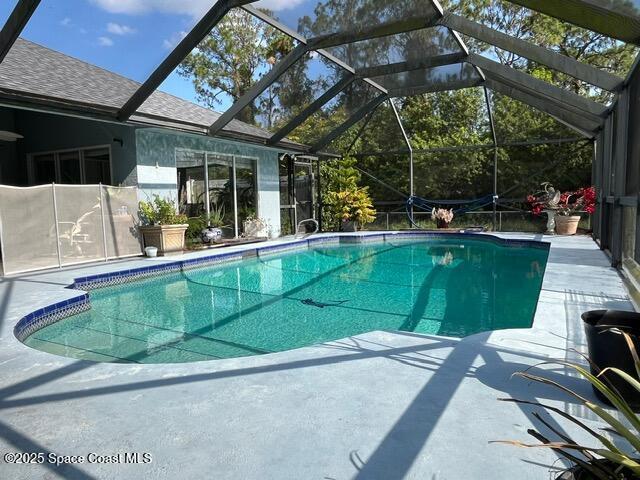 130 Nemo Cir NE, Palm Bay, FL 32907 - outdoor pool with a patio area and glass enclosure