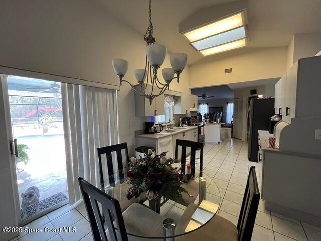 130 Nemo Cir NE, Palm Bay, FL 32907 - dining room featuring light tile patterned floors, a chandelier, high vaulted ceiling, and a ceiling fan