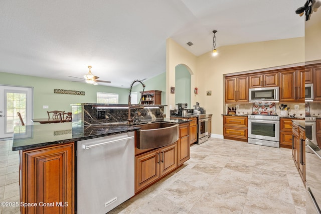 1317 Mohegan Ter SE, Palm Bay, FL 32909 - kitchen with stainless steel appliances, decorative backsplash, brown cabinetry, and healthy amount of natural light