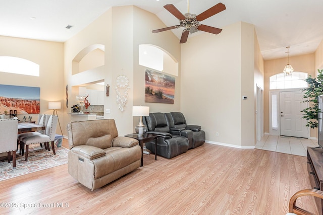 570 Shell Cove Dr, Melbourne, FL 32940 - living room featuring high vaulted ceiling, light wood-style flooring, ceiling fan, and baseboards