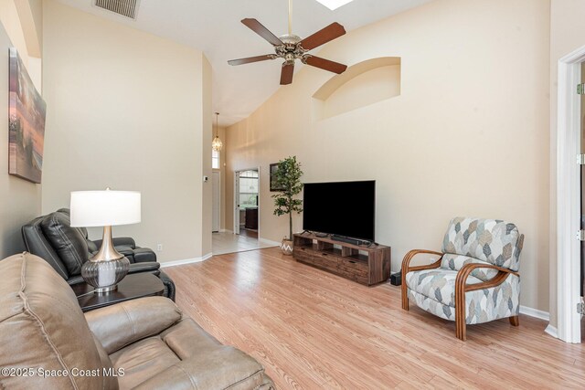 570 Shell Cove Dr, Melbourne, FL 32940 - living area with high vaulted ceiling, light wood-style flooring, ceiling fan, and baseboards