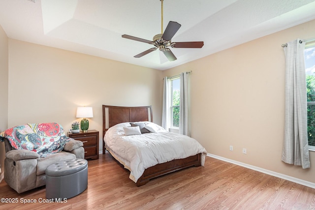 570 Shell Cove Dr, Melbourne, FL 32940 - bedroom featuring multiple windows, light wood-type flooring, baseboards, and ceiling fan