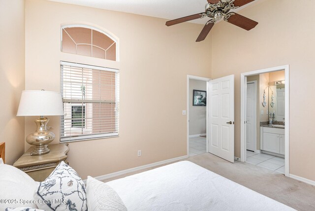 570 Shell Cove Dr, Melbourne, FL 32940 - bedroom with light colored carpet, a towering ceiling, baseboards, and ensuite bath
