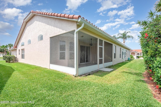 570 Shell Cove Dr, Melbourne, FL 32940 - view of property exterior featuring a sunroom, a lawn, stucco siding, a ceiling fan, and a tile roof
