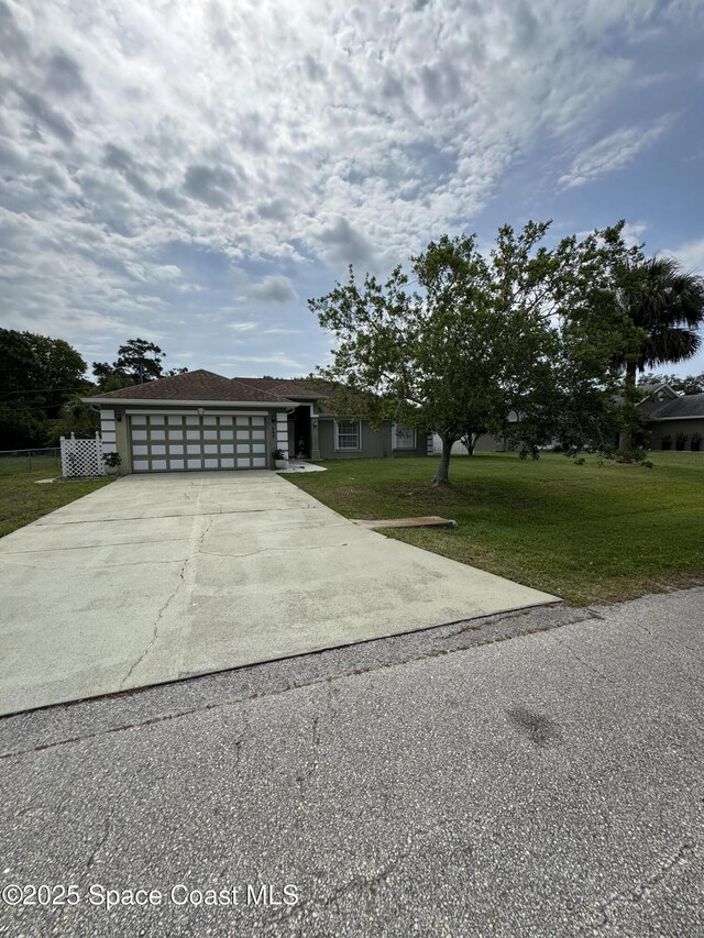 157 Lehigh Ave SE, Palm Bay, FL 32909 - view of front of home featuring driveway, a front lawn, and an attached garage