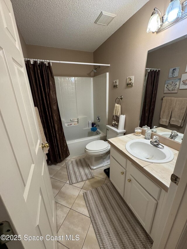 157 Lehigh Ave SE, Palm Bay, FL 32909 - full bathroom with vanity, a textured ceiling, shower / bath combo with shower curtain, tile patterned flooring, and toilet