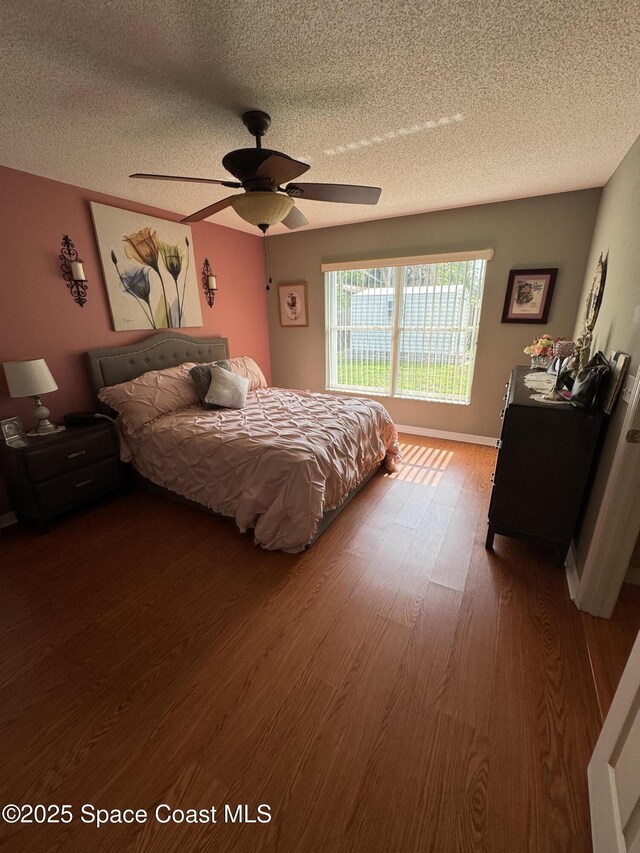 157 Lehigh Ave SE, Palm Bay, FL 32909 - bedroom featuring a textured ceiling, wood finished floors, a ceiling fan, and baseboards